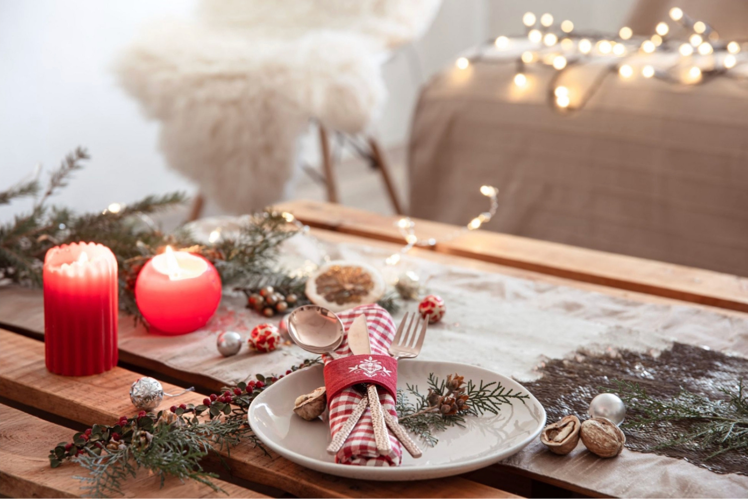 Mesa de Navidad decorada con velas, ramas verdes y adornos festivos