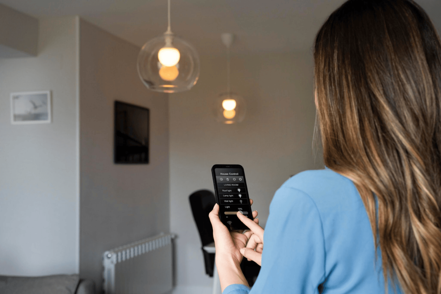 Mujer controlando luces inteligentes del salón con smartphone y app de domótica para casa conectada