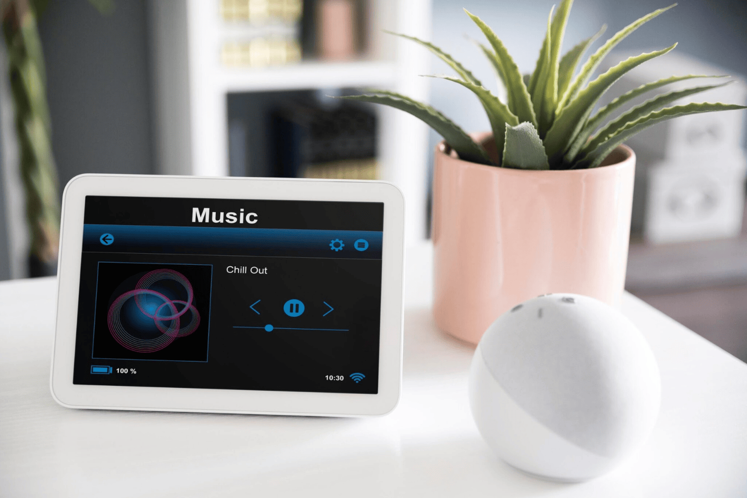 Tablet con reproductor de música inteligente mostrando canción Chill Out en sistema domótico de hogar